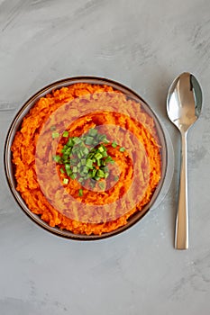 Homemade Creamy Mashed Sweet Potatoes with MIlk and Butter in a Bowl on a gray background, top view