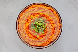 Homemade Creamy Mashed Sweet Potatoes with MIlk and Butter in a Bowl on a gray background, top view. Flat lay, overhead, from