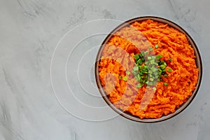 Homemade Creamy Mashed Sweet Potatoes with MIlk and Butter in a Bowl on a gray background, top view. Space for text