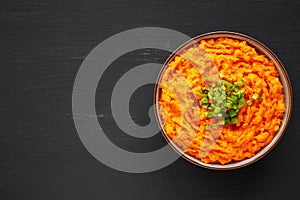 Homemade Creamy Mashed Sweet Potatoes with MIlk and Butter in a Bowl, top view. Space for text