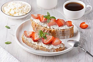 Homemade Crispbread toast with Cottage Cheese and Strawberry on white wooden board