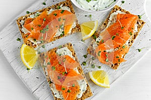 Homemade Crispbread toast with Smoked Salmon, Melted Cheese and cress salad. on white wooden board