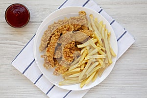 Homemade Crispy Chicken Tenders and French Fries on a white wooden background, top view. Flat  lay, overhead, from above