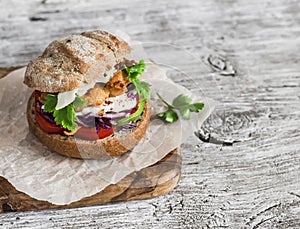 Homemade crispy fish burger on a rustic wooden board