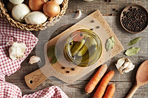 Homemade cucumber pickles or gherkins in a glass jar on a table