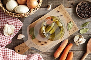 Homemade cucumber pickles or gherkins in a glass jar on a table