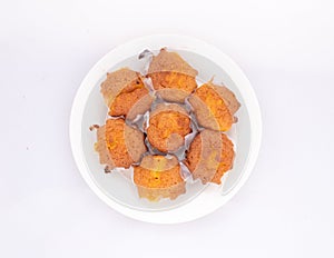 Homemade cupcakes in ceramic plate on white background. Top view