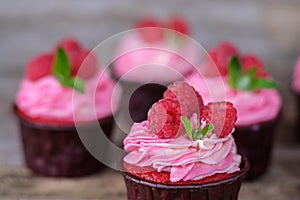 Homemade cupcakes with pink cream and raspberry