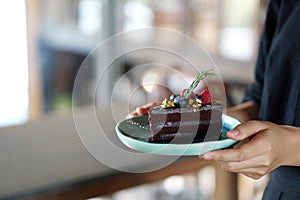 Homemade dark chocolate cake with fresh strawberry and blueberry on table, copy space.