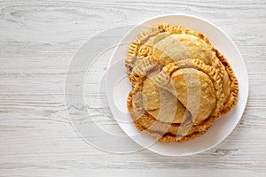 Homemade Deep Fried Italian Panzerotti Calzone with sauce on a white plate on a white wooden background, top view. Flat lay,