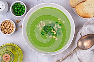 Homemade delicacy green pea soup cream with mint and pine nuts