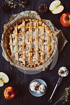 Homemade delicious apple pie with ice cream on the wooden table.