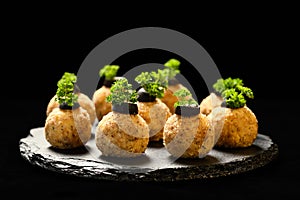 Homemade delicious ball appetizer with chicken, cheese, eggs and walnuts, decorated with parsley and olive slices, served on