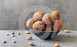 Homemade delicious Cocoa balls: chocolate balls cakes in a black plate against grey background