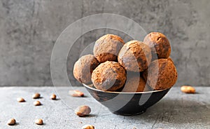 Homemade delicious Cocoa balls: chocolate balls cakes in a black plate against grey background