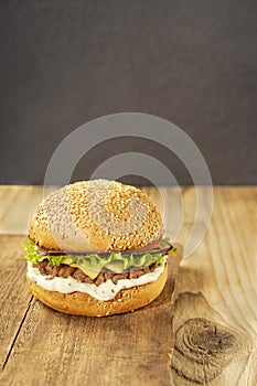 Homemade delicious hamburger on a wooden table, rustic style. Fast food. Space for the text