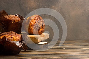 Homemade delicious muffins on wooden background close-up