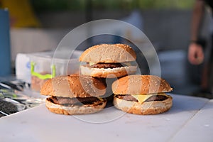 Homemade delicious three mini burgers served with salad, sauce and french fries