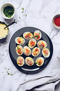 Homemade deviled eggs with salmon on a black background.