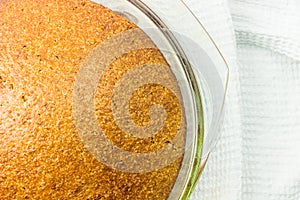 Homemade dietary bread of amaranth and spelt whole grain flour. Fresh baked bread in glass baking dish top view.