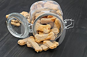 Homemade dog bones spilling from a glass jar.