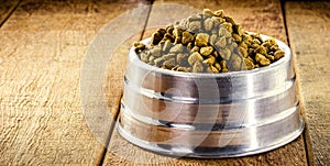 Homemade dog food in metallic bowl, healthy homemade food for puppies, rustic wooden background
