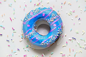 Homemade doughnuts with colored frosting and sprinkles on a gray background