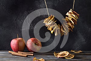 Homemade dried apples with cinnamon, apple chips on a wooden background. Delicious healthy snack
