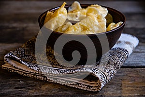 Homemade dumplings in clay pots on the kitchen table, fork and folklor napkin.