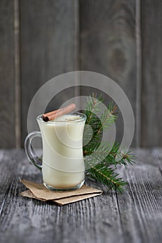Homemade eggnog with cinnamon for Christmas and winter holidays on wooden table