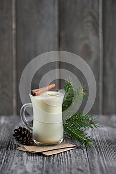 Homemade eggnog with cinnamon for Christmas and winter holidays on wooden table