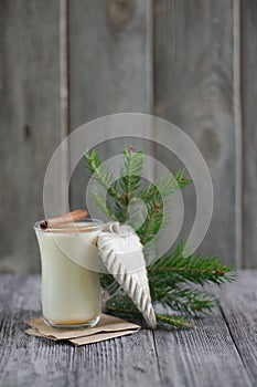 Homemade eggnog with cinnamon for Christmas and winter holidays on wooden table