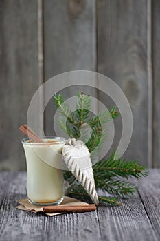 Homemade eggnog with cinnamon for Christmas and winter holidays on wooden table