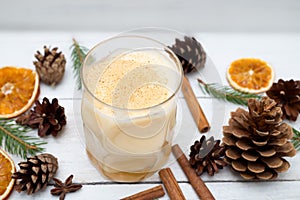 Homemade eggnog with cinnamon on wooden table. Flat lay