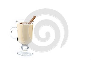 Homemade eggnog with cinnamon on wooden table. Typical Christmas dessert isolated on white background