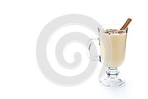 Homemade eggnog with cinnamon on wooden table. Typical Christmas dessert isolated on white background