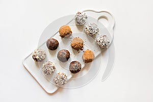 Homemade energy balls with cacao and nuts on white. Healthy food for children, sweets substitute