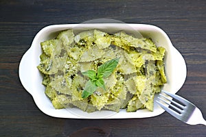 Homemade Farfalle Pasta with Pesto Sauce on Wooden Table