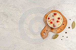 Homemade fermented sauerkraut with carrots and cranberries on the board, light gray background