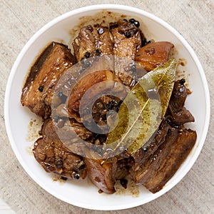 Homemade Filipino Adobo Pork in a bowl, overhead view. Flat lay, from above, top view. Closeup