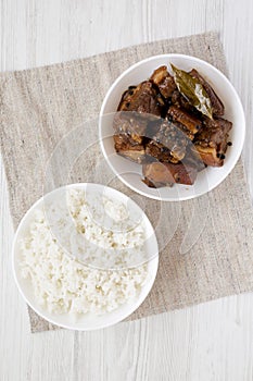 Homemade Filipino Adobo Pork with rice on a white wooden background, top view. Flat lay, overhead, from above