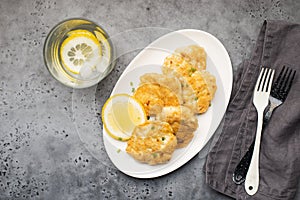 Homemade fish cakes with french fries on white plate close up