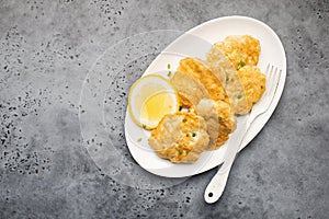 Homemade fish cakes with french fries on white plate close up