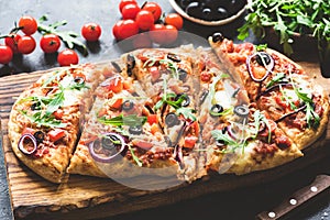 Homemade flatbread pizza sliced on wooden cutting board