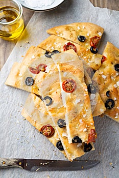 Homemade focaccia with black olives, cherry tomatoes, rosemary and salt