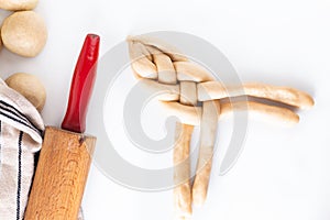 Homemade food concept process braiding bread braid challah dough on white background with copy space