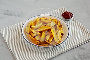 Homemade French Fries with Ketchup on a Plate, side view. Close-up