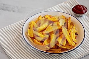 Homemade French Fries with Ketchup on a Plate, side view. Close-up