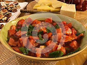 Homemade Fresh Juicy Tomato Salad with Arugula Leaves in Ceramic Bowl.