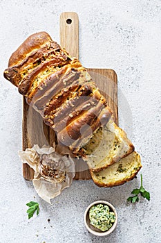 Homemade fresh pull apart bread with herbs parsley, thyme, rosemary, dill, garlic, cheese and spicy butter